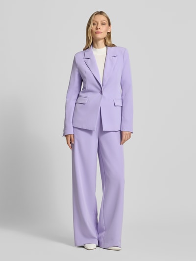 Frauenmodel trägt Slim Fit Blazer mit Pattentaschen Modell 'Isa' von GUIDO MARIA KRETSCHMER WOMAN, Fliederfarbe, Material-Mix mit Stretch-Anteil, Reverskragen, Knopfverschluss, Ganzkörperansicht von vorne.