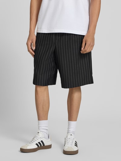 Mężczyznamodel nosi szorty z elastycznym pasem model 'CRISTIANO' od Redefined Rebel, mieszanka materiałów z dodatkiem streczu, krój relaxed fit, szerokość w rozmiarze M: 42 cm, długość wewnętrzna nogawki w rozmiarze M: 27 cm, widok na całe ciało z przodu.