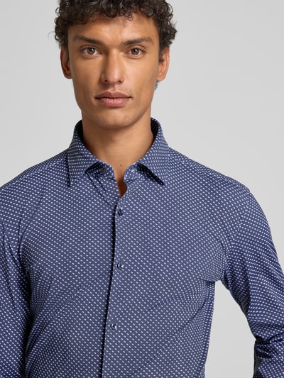 Männermodel trägt Slim Fit Businesshemd mit Kentkragen Modell 'KENNO' von HUGO, Optik: Allover-Muster, Nahaufnahme Oberkörper.