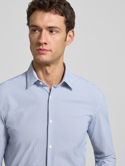 Männermodel trägt Slim Fit Businesshemd mit Allover-Muster Modell 'HANK' von BOSS, Kentkragen, feine Struktur, Nahaufnahme Oberkörper.