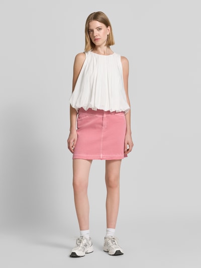 Vrouwenmodel draagt Straight Fit Minirock in Denim-Optik van Marc Cain, roze katoenmix met steek- en achterzakken, knoop- en ritssluiting, volledige lichaamsvooraanzicht.