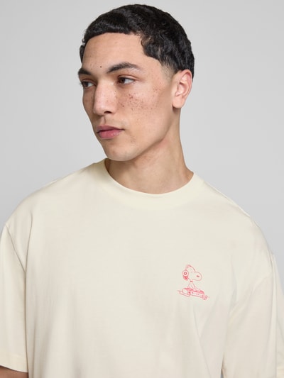 Männermodel trägt Regular Fit T-Shirt aus reiner Baumwolle Modell 'PEANUTS' von Only & Sons mit Peanuts® Print, Nahaufnahme Oberkörper.