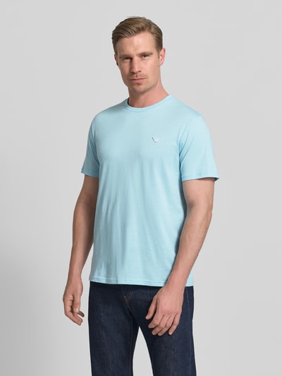 Männermodel trägt T-Shirt mit Logo-Patch und Rundhalsausschnitt von Emporio Armani, Farbe Hellblau, Reine Baumwolle, Modern Fit, Ganzkörperansicht von vorne