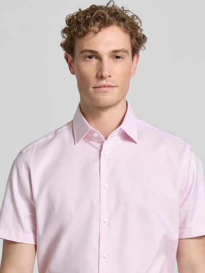 Männermodel trägt Regular Fit Business-Hemd mit Kentkragen von Christian Berg Men in zartem Rosa aus Reine Baumwolle, Nahaufnahme Oberkörper.