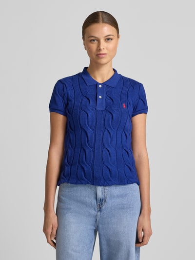 Kobieta modelka nosi koszulkę polo z wyhaftowanym logo od Polo Ralph Lauren, bawełna, krój regular fit, kołnierzyk polo, listwa guzikowa, długość tyłu przy rozmiarze S 55 cm, widok z przodu na całą sylwetkę.