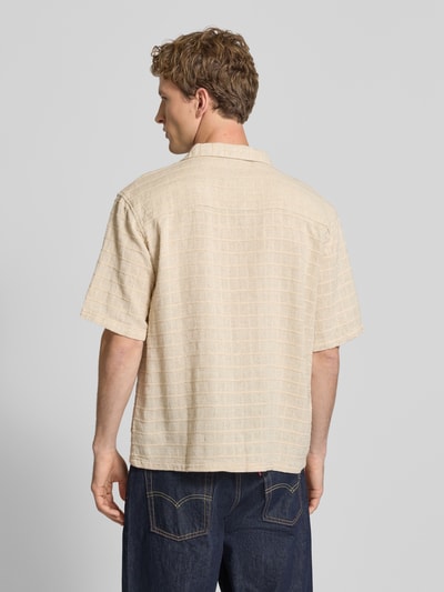 Männermodel trägt Oversized Freizeithemd mit Strukturmuster Modell 'Corey' von Redefined Rebel im Beige-Ton, Leinen-Baumwoll-Mix, Ganzkörperansicht Rückansicht.