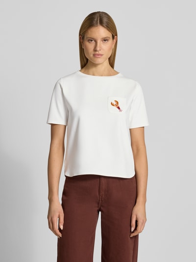 Frauenmodel trägt T-Shirt mit Brusttasche und Motiv von More & More, weiß, kurze Ärmel, Viskose-Mix mit Stretch-Anteil, Regular-Fit, Perlen, Rundhalsausschnitt, Rückenlänge bei Größe 36: 54 cm, Ganzkörperansicht von vorne.