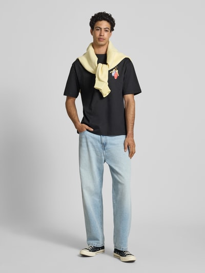 Männermodel trägt Boxy Fit T-Shirt aus reiner Baumwolle Modell 'FRED ESCAPE' von Only & Sons, Optik: Unifarben, Passform: Boxy-Fit, Motiv-Print, Rundhals, Ärmelform: Kurzarm, Materialverarbeitung: Jersey, Herren T-Shirt, Ganzkörperansicht von vorne.