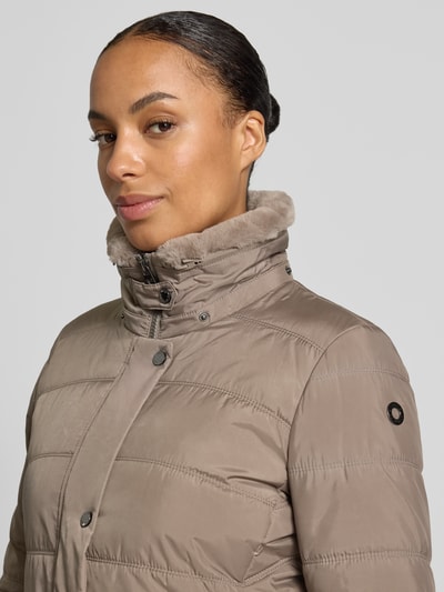 Vrouwenmodel draagt Mantel in Stepp-Optik van FUCHS SCHMITT in taupe met stiksels, getailleerd, afneembare capuchon, gevoerde opstaande kraag, ritssluiting, borstwijdte 48 cm, schouderbreedte 42 cm, mouwlengte 65 cm, ruglengte 90 cm, detailopname bovenlichaam.