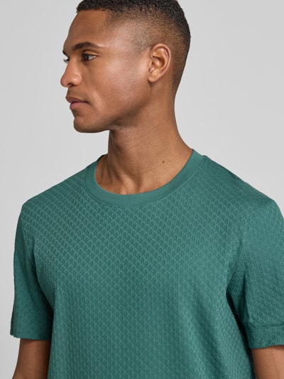 Męski model nosi T-Shirt z geripptem Rundhalsausschnitt von JOOP! Collection z bawełny w regular fit; zbliżenie na górną część ciała.