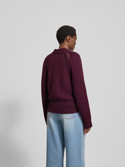 Frauenmodel trägt Strickjacke aus Alpaka-Mix mit Woll-Anteil von Closed in Dunkelrot, lockerer Schnitt, gerippte Abschlüsse, Rückenlänge 58 cm, Ganzkörperansicht Rückansicht.
