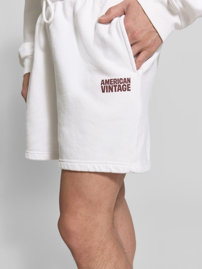 Männermodel trägt Shorts mit Logo Modell 'PLIZZY' von American Vintage in Weiß aus Reine Baumwolle, Relaxed-Fit, Nahaufnahme Oberschenkel.