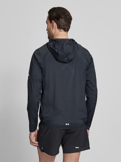 Männermodel trägt Windbreaker mit Kapuze und Logo von Salomon, dunkle Farbe, Material-Mix mit Stretch-Anteil, Ganzkörperansicht Rückansicht. Rückenlänge 72 cm, Schulterbreite 46 cm, Brustweite 56 cm, Ärmellänge 69 cm, Regular-Fit.