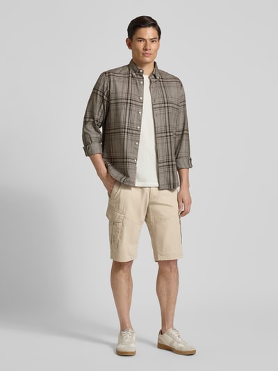 Männermodel trägt Relaxed Fit Cargoshorts aus reiner Baumwolle von s.Oliver BLACK LABEL in Optik: Unifarben mit Label-Patch, Ganzkörperansicht von vorne.