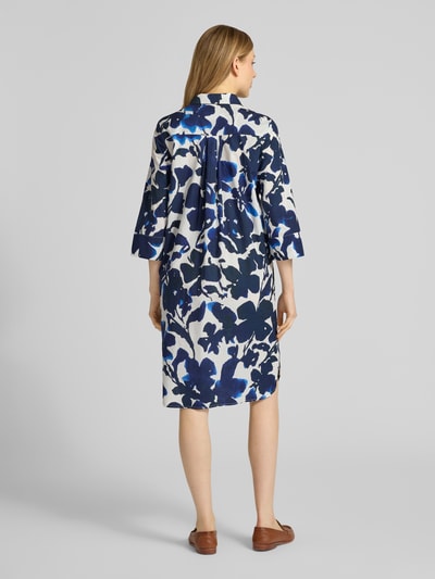 Frauenmodel trägt Knielanges Hemdblusenkleid im Allover-Look von WHITE LABEL aus reiner Baumwolle mit floralen Blautönen, gerader Schnitt, Perlen und 3/4-Arm, Ganzkörperansicht Rückansicht.