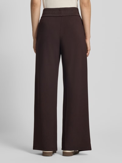 Vrouwenmodel draagt Straight Fit Sweatpants uit elastische viscosemix van Armani Exchange, donkerbruin, labeldetail, pijpsplitten, elastische band, binnenbeenlengte maat S 77 cm, totaalbeeld achterkant