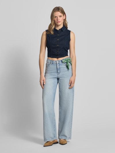 Frauenmodel trägt Cropped Jeansbluse mit Label-Patch von Guess Jeans in Dunkelblau, Reine Baumwolle, Körpernaher-Schnitt, Kentkragen, Knopfleiste, Rückenlänge bei Größe S: 43 cm, Ganzkörperansicht von vorne.