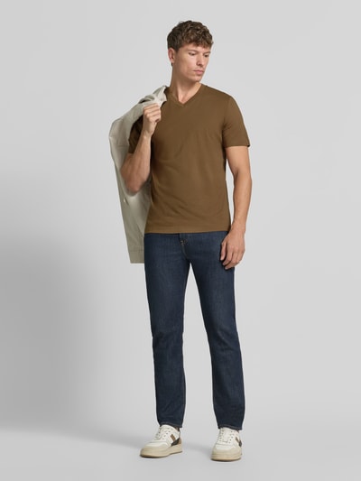 Männermodel trägt Regular Fit T-Shirt aus reiner Baumwolle von s.Oliver RED LABEL, braun, zur blauen Jeans, Ganzkörperansicht von vorne.
