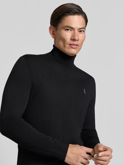 Männermodel trägt schwarzen Regular Fit Rollkragenpullover aus reiner Wolle von Polo Ralph Lauren, glatte Textur, Nahaufnahme Oberkörper.