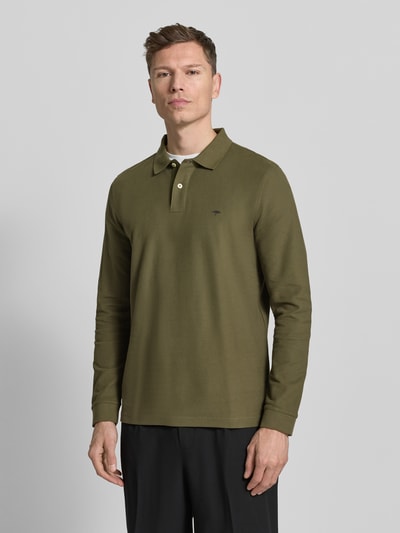 Männermodel trägt Poloshirt mit Label-Stitching von Fynch-Hatton in Olivgrün, Reine Baumwolle, Regular-Fit, Polokragen, Knopfleiste, gerippte Ärmelabschlüsse, Rückenlänge 37 cm bei Größe M, Ganzkörperansicht von vorne.