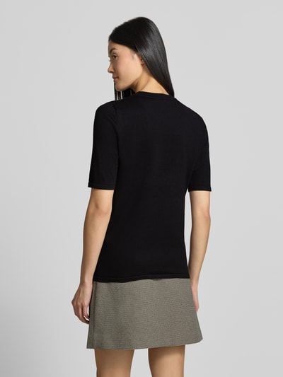 Frauenmodel trägt Regular Fit Pullover in Strick-Optik Modell "LULS" von ICHI, schwarz, kurzärmelig, Rundhalsausschnitt, Rückenansicht, Ganzkörperansicht Rückansicht.