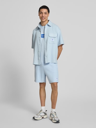 Męski model nosi Regular Fit Sweatshorts aus Baumwoll-Mix Modell 'NUWAFFLO' von HUGO, jednokolorowy, mieszanka bawełny, naszywka z logo, tunel, elastyczny ściągacz, wpuszczane kieszenie, kieszeń z tyłu, ganzkörperansicht von vorne.
