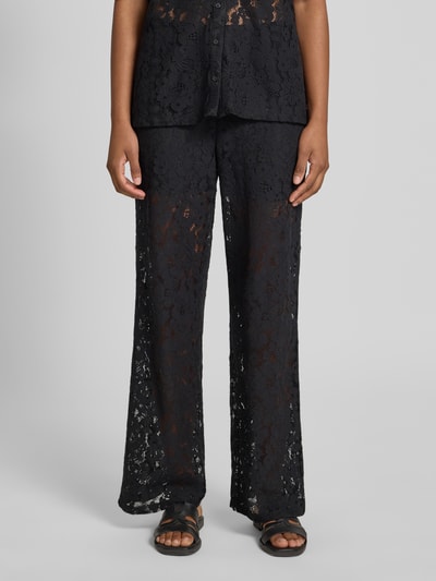 Frauenmodel trägt Weite HOSE in Spitzen-Optik Modell 'HONEY' von Vero Moda, Schwarz, Regular-Fit, Materialverarbeitung: Lochspitze, Nahaufnahme Oberkörper.