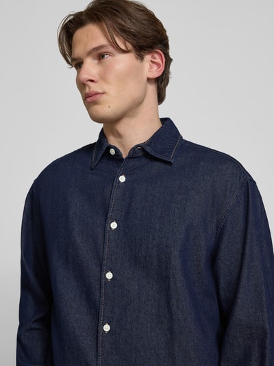Männermodel trägt Regular Fit Jeanshemd mit Kentkragen Modell 'NORREBRO' von Jack & Jones, dunkelblau, reine Baumwolle, Nahaufnahme Oberkörper.