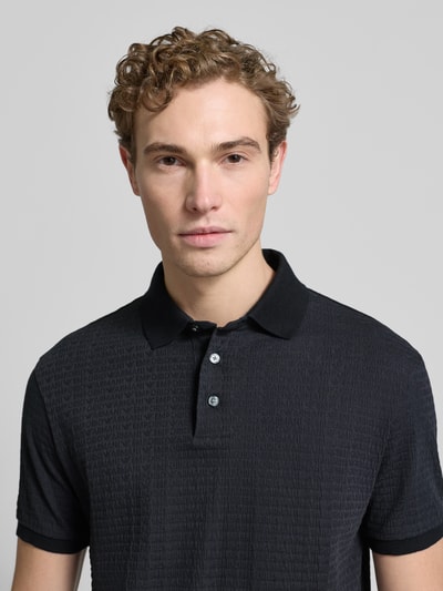 Männermodel trägt Regular Fit Poloshirt mit Strukturmuster von Emporio Armani aus reiner Baumwolle mit Polokragen, Knopfleiste, Nahaufnahme Oberkörper.