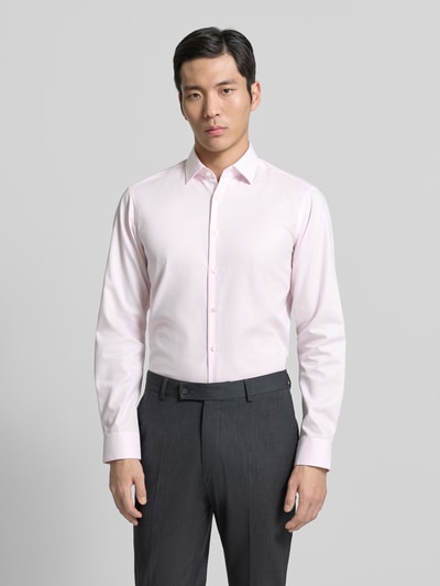 Männermodel trägt Regular Fit Business Hemd aus Baumwolle mit Kentkragen von Jake*s, hellrosa, glatte Struktur, Ganzkörperansicht von vorne.