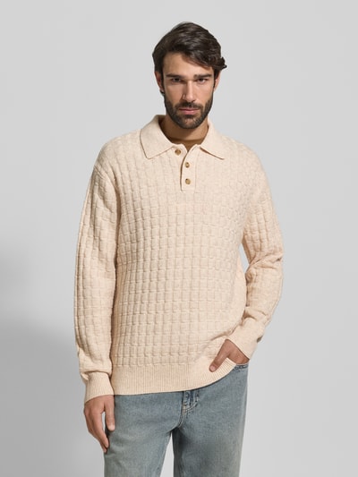 Männermodel trägt Strickpullover mit Strukturmuster Modell 'Gustav' von Les Deux, Woll-Anteil, Regular-Fit, Polokragen, Knopfleiste, beige, Ganzkörperansicht von vorne.