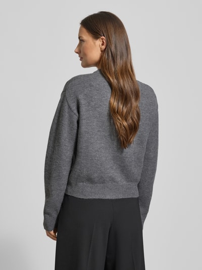 Frauenmodel trägt Cardigan mit Rundhalsausschnitt Modell 'FELIPE' von Mango, Woll-Anteil Material-Mix, gerader Schnitt, Rückansicht.