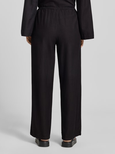 Frauenmodel trägt schwarze Stoffhose aus Viskose-Mix Modell 'PRISILLA' von Vila mit Wide Leg und Leinen-Viskose-Anteil, Ganzkörperansicht Rückansicht.