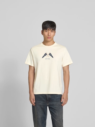 Männermodel trägt Regular Fit T-Shirt mit Logo-Print von Forét in Creme, reine Baumwolle, Rundhalsausschnitt, Ganzkörperansicht von vorne.