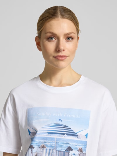 Frauenmodel trägt T-Shirt mit Motiv-Print Modell 'Beach Dogs' von monari, weiß, Rundhalsausschnitt, reine Baumwolle, Nahaufnahme Oberkörper.