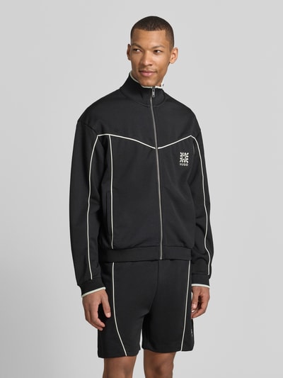 Männermodel trägt Relaxed Fit Sweatjacke aus Baumwoll-Mix Modell 'DARYNT' von HUGO, mehrfarbig mit Kontraststreifen, Logo-Stitching, Reißverschluss, seitliche Eingrifftaschen, Langarm, gerippter Ärmel- und Rumpfabschluss, Ganzkörperansicht von vorne.