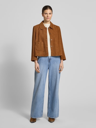 Kobiece model nosi kurtkę skórzaną z koziej skóry welurowej Bash Lederjacke mit Umlegekragen Modell 'MILAS', krój regular fit, listwa guzikowa, kieszeń z zapięciem na guzik, brązowy kolor, gładka tekstura, Ganzkörperansicht von vorne.