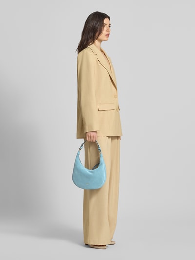 Frauenmodel trägt Shoulder Bag aus echtem Leder Modell 'Nana' von Abro, hellblau, Logo-Detail, Hauptfach mit Reißverschluss, Ganzkörperansicht von vorne.