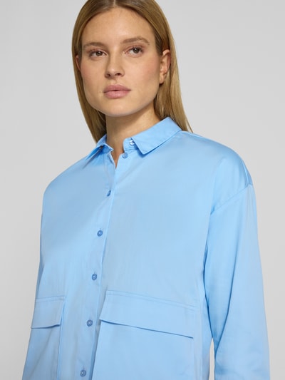 Frauenmodel trägt Regular Fit Bluse mit Pattentaschen von Smith and Soul aus Baumwoll-Mix in Hellblau, Hemdblusenkragen, Nahaufnahme Oberkörper.