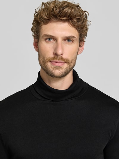 Männermodel trägt Regular Fit Longsleeve aus reiner Baumwolle mit Rollkragen von Christian Berg Men in Schwarz, Nahaufnahme Oberkörper.