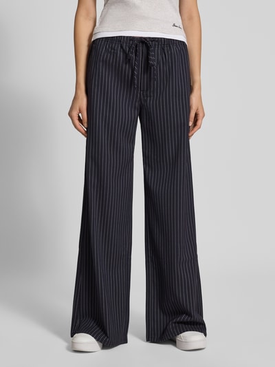 Vrouwenmodel draagt Wide Fit Hose mit elastischem Bund van GUESS, donkerblauw met witte strepen, Bandplooien, Tunnelkoord, Ganzkörperaanzicht van voren. Bandwijdte maat 27/32: 41 cm, Binnenbeenlengte maat 27/32: 80 cm.