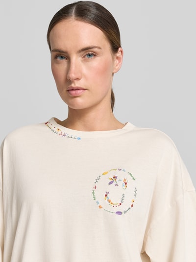 Frauenmodel trägt Relaxed Fit T-Shirt mit floralem Stitching von JAKE*S STUDIO WOMAN, Damen T-Shirt in Creme mit Rundhalsausschnitt, Halbarm, Rückenlänge 64 cm, Detailaufnahme Oberkörper.