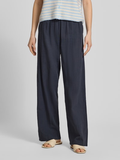 Frauenmodel trägt Loose Fit Weite Damen Hose aus reiner Baumwolle Modell 'TIZANA' von Only, Optik: Unifarben, Eingrifftasche, Mid Waist, elastischer Bundabschluss mit Tunnelzug, Struktur: weiches Material, Farbe: Dunkelblau, Ganzkörperansicht von vorne.