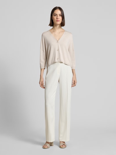 Frauenmodel trägt Schimmernde Strickjacke mit 3/4-Arm von Comma mit V-Ausschnitt, Knopfleiste, Relaxed-Fit, Ganzkörperansicht von vorne.
