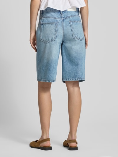 Frauenmodel trägt Barrel Shorts im 5-Pocket-Design von Gina Tricot aus Reine Baumwolle in hellem Denim, Ganzkörperansicht Rückansicht.