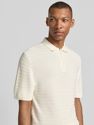 Męskimodel nosi Regular Fit Poloshirt mit kurzem Reißverschluss von MCNEAL z mieszanki bawełny i wiskozy, fakturowany wzór, kołnierzyk polo, krótki zamek błyskawiczny, kolor kremowy, długość tyłu 69 cm, długość rękawów 26 cm, ujęcie: z przodu, zbliżenie górnej części ciała.