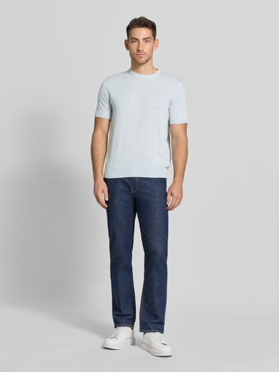Männermodel trägt Strickshirt mit Rundhalsausschnitt von MARKUP in Hellblau, kombiniert mit Jeans, Regular Fit, Ganzkörperansicht von vorne.