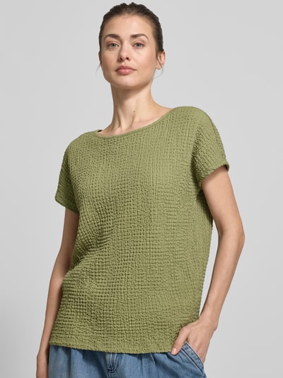 Modelka kobieca nosi Relaxed Fit T-Shirt mit Strukturmuster od s.Oliver RED LABEL, kolor oliwkowy, faktura crinkle, krótki rękaw, widok na górną część ciała z przodu.