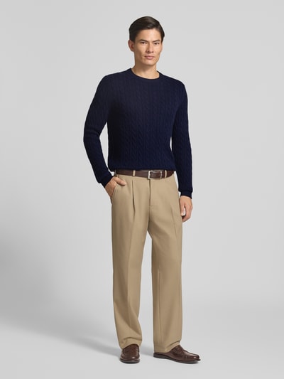 Männermodel trägt Slim Fit Strickpullover aus reinem Kaschmir mit Zopfmuster von Christian Berg Men in Dunkelblau und Beige, Ganzkörperansicht von vorne. Reines Kaschmir, Langarm, Rundhalsausschnitt, gerippte Abschlüsse, dezente Struktur, Rückenlänge und Ärmellänge je 70 cm.