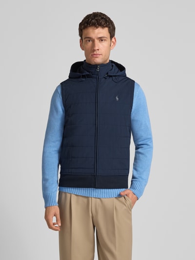 Männermodel trägt Steppweste mit Kapuze und Label-Stitching von Polo Ralph Lauren in Navy, Regular Fit, Reißverschluss, Ganzkörperansicht von vorne.